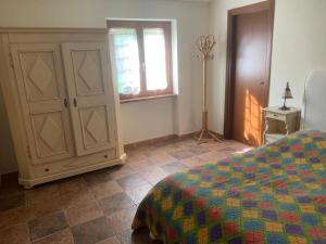 1 dormitorio con 1 cama, armario y ventana en Il Bosso, en Cagli