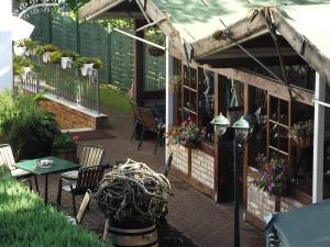 a patio with a table and chairs and flowers at Pension Am Strand in Juliusruh