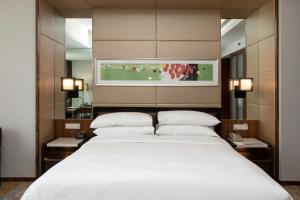 a bedroom with a large white bed with two pillows at Sheraton Grand Shanghai Pudong Hotel & Residences in Shanghai