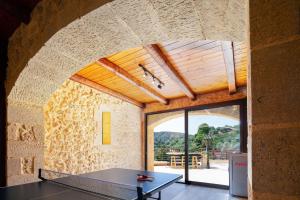 una mesa en una habitación con una pared de piedra en Kotinos Luxury Villa, en La Canea