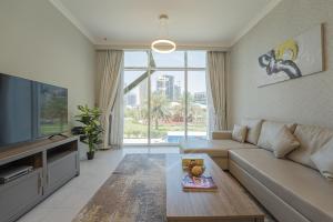 a living room with a couch and a tv at KeyHost - Regent Court JVC - K180 in Dubai