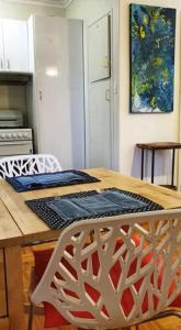 a kitchen with a wooden table with two chairs at Elwood Beach Apartment (2 min walk from beach) in Melbourne