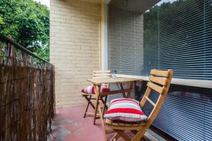 una mesa de patio y 2 sillas en el porche en Elwood Beach Apartment (2 min walk from beach) en Melbourne
