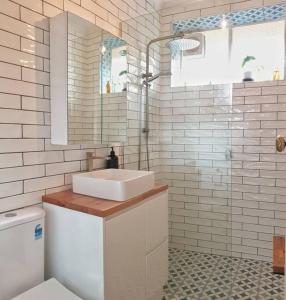 a white bathroom with a sink and a toilet at Elwood Beach Apartment (2 min walk from beach) in Melbourne