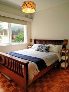 a bedroom with a large bed with a window at Elwood Beach Apartment (2 min walk from beach) in Melbourne