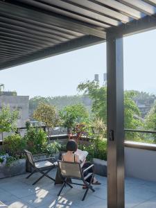 a woman sitting in a chair on a roof at Jiangnan House Chaozhou in Chaozhou