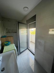 a bathroom with a tub and a sink and a window at Apartman Mara Vodice in Vodice