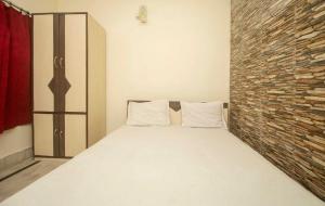 Cama en habitación con pared de ladrillo en OYO Hotel Prasant Sagar, en Jaigaon
