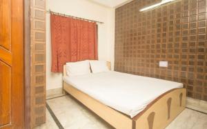 a small bed in a room with a brick wall at OYO Hotel Prasant Sagar in Jaigaon