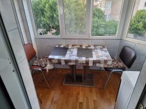 a table and chairs in a room with two windows at Rozelor in Mangalia