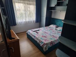 a small bedroom with a bed and a television at Rozelor in Mangalia