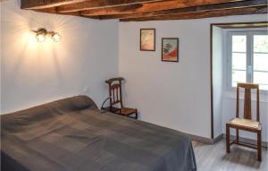 een slaapkamer met een bed en 2 stoelen en een raam bij Cozy Apartment In Aldudes With House Sea View in Aldudes