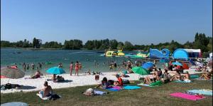 a crowd of people on a beach with umbrellas at Chez Chris in Libourne