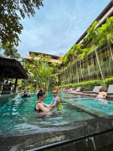 a woman and a child in a swimming pool at Residence Indochine Suite in Siem Reap