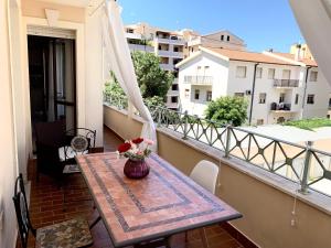 un tavolo su un balcone con un vaso di fiori di Alghero Heart ad Alghero