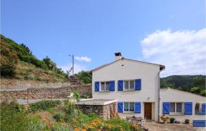 una casa blanca con persianas azules en una colina en Beautiful Home In Lamastre With Kitchenette, en Lamastre