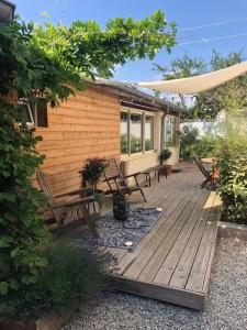 a wooden deck with chairs and a house at - Le Patio - Calme, Chaleureux, Unique in Besançon