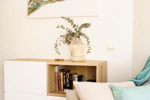 a vase with a plant on a book shelf at Dalex in Salou