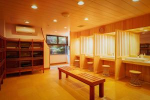 a large bathroom with a bench and a sink at Yuyado Unzen Shinyu in Unzen