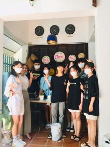 a group of people standing in a room wearing masks at Cheriladyhomestayhue in Hue