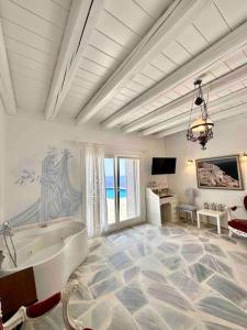 baño blanco grande con bañera y TV en Divine Blue Villa Nano in Koundouros Kea Cyclades with pool and sea view, en Koundouros
