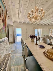 Koundouros的住宿－Divine Blue Villa Nano in Koundouros Kea Cyclades with pool and sea view，一间带大桌子和吊灯的用餐室