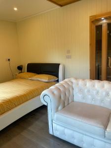 a bedroom with a white couch and a bed at Lochness Glam Lodges in Inverness