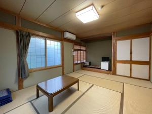 a living room with a table and a window at Hotel Sejour Mint in Hakuba in Hakuba