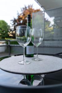 Dois copos de vinho numa mesa com uma garrafa de vinho em Businessapartment I Balkon I Messe I Parken I schnelles WLAN em Essen