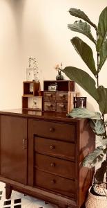 a wooden dresser in a room with a plant at Thanh Xuân House in Xuan An