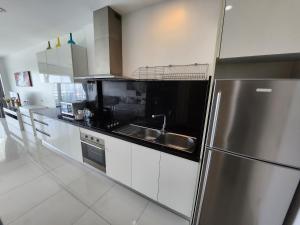 a kitchen with white cabinets and a stainless steel refrigerator at Condo Express View Talay 6 in Pattaya Central
