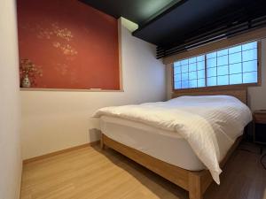 a bedroom with a white bed and a window at 継TSUNAGU 空蝉Utsusemi帚木Hahakigi in Kyoto