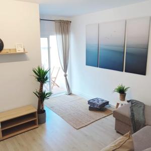 ein Wohnzimmer mit einem Sofa und einem Tisch in der Unterkunft Piso nuevo a 2 minutos de la playa in Sant Feliu de Guixols