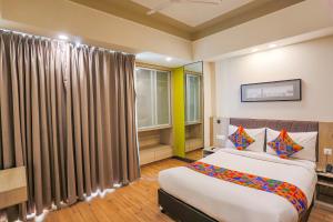 Un dormitorio con una cama grande y una ventana en FabHotel Sapphire 83, en Gurgaon