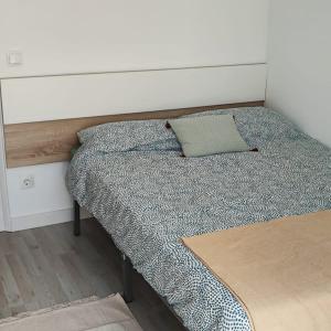- un lit avec une tête de lit et un oreiller dans l'établissement Piso nuevo a 2 minutos de la playa, à Sant Feliu de Guíxols