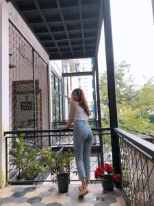 a woman standing on a balcony with a skateboard at Cheriladyhomestayhue in Hue