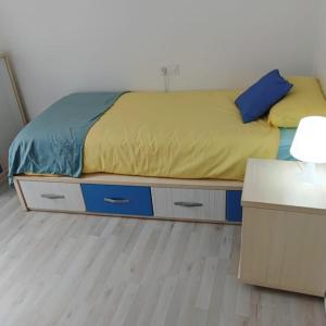 - une chambre dotée d'un lit avec des draps bleus et jaunes dans l'établissement Piso nuevo a 2 minutos de la playa, à Sant Feliu de Guíxols