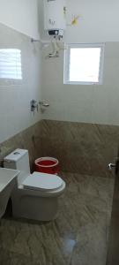 a bathroom with a toilet and a sink and a window at Beach Dreamz Villa 2 BHK Near Pondy and Auroville in Marakkānam