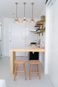 a kitchen with a wooden table and two stools at Sea Green Boutique Rooms in General Luna