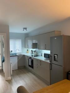 a kitchen with white cabinets and a stainless steel refrigerator at The Sorting House in Hunstanton
