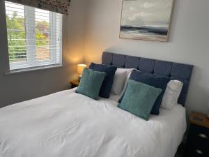 sypialnia z białym łóżkiem z 2 zielonymi poduszkami w obiekcie The Sorting House w mieście Hunstanton