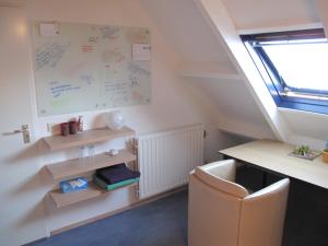 een kamer met een bureau en een witte plank aan de muur bij B&B Vincent's Attic in Ede