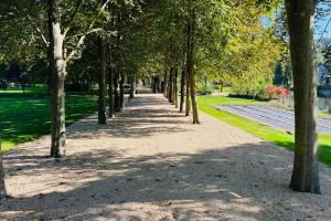 a row of trees on a sidewalk in a park at Jacuzzi - BBq - Jardin - Garden Lodge - Le Tulipier in Olne