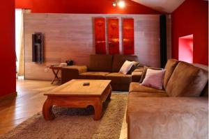 a living room with a couch and a coffee table at Jacuzzi - BBq - Jardin - Garden Lodge - Le Tulipier in Olne