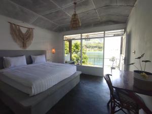 图克图克Hub Tata Guesthouse的一间卧室，里面有一张床、一张桌子和一扇窗户