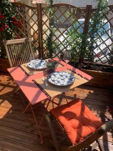 a table and chairs on a deck with a table and plates at Studio Oustaou à Château Gombert in Marseille