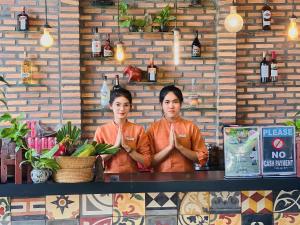 two people standing at a counter in a bar at Residence Indochine Suite in Siem Reap