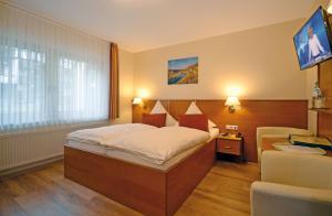 een hotelkamer met een bed en een televisie bij Hotel Burgfrieden in Beilstein