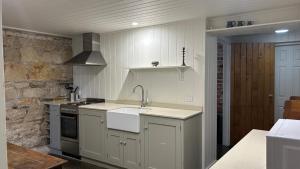 a kitchen with a sink and a stove at Lumeah - Servant Quarters in Hobart