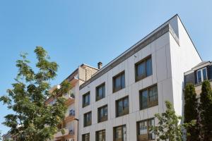 un edificio blanco con árboles delante de él en Résidence du Lys - Perrin Apartments en Luxemburgo